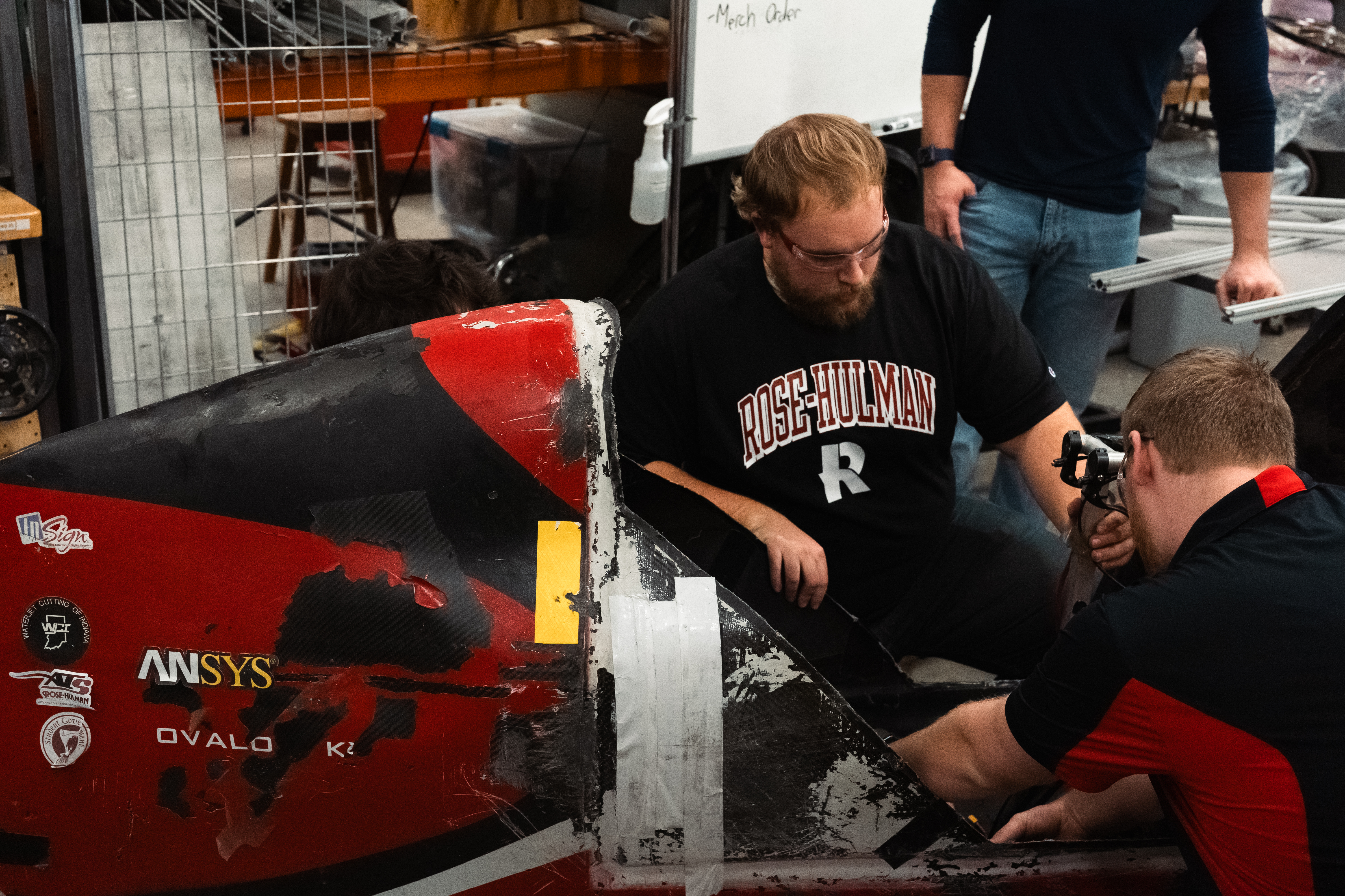Students work on the vehicle, a recumbent bike encased in an aerodynamic shell.